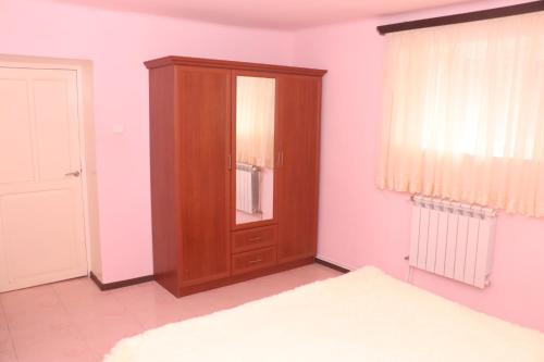 a bedroom with a wooden cabinet next to a bed at Уютные апартаменты в малом центре Еревана in Yerevan