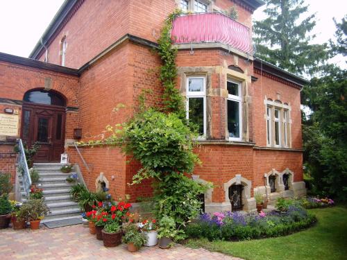 a brick house with flowers in front of it at Ferienwohnung Markert in Blankenburg