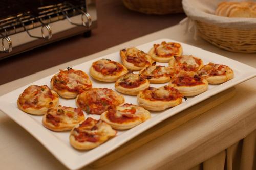 a plate of small pizzas on a table at Hotel Alibi in Rimini
