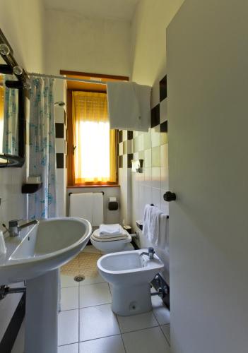 a white bathroom with a sink and a toilet at Hotel Letizia in Orte