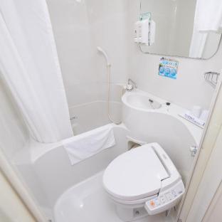 a white bathroom with a toilet and a sink at Super Hotel Shinyokohama in Yokohama