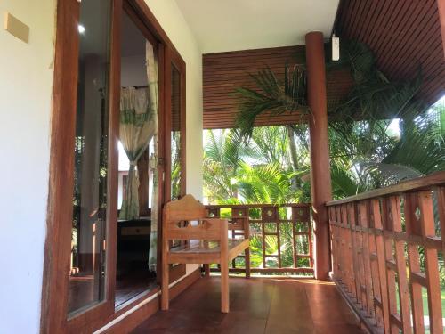 a porch of a house with a wooden chair at Pai Loess Resort in Pai