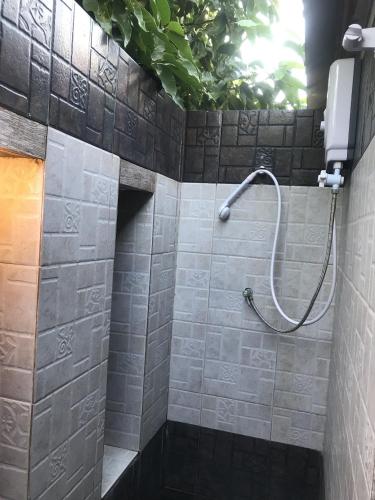 a shower in a bathroom with a tile wall at Pai Loess Resort in Pai