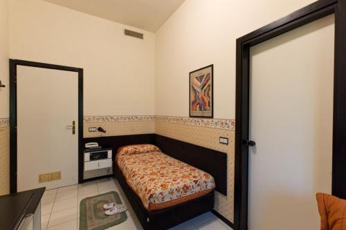 a small bedroom with a bed and a mirror at Hotel Letizia in Orte
