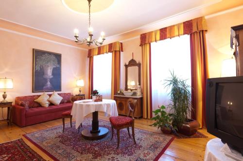 a living room with a red couch and a table at Gasthof Bräuer - Familie Eibensteiner in Weißkirchen in Steiermark