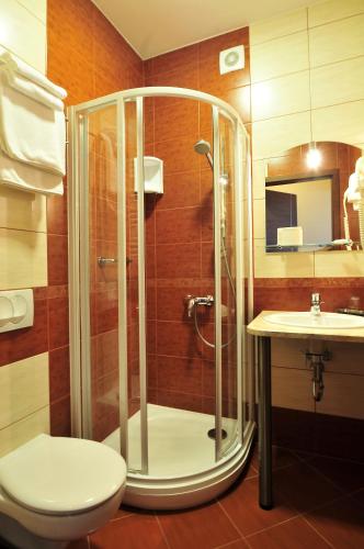 a bathroom with a shower and a toilet and a sink at Hotel Continental in Krynica Morska