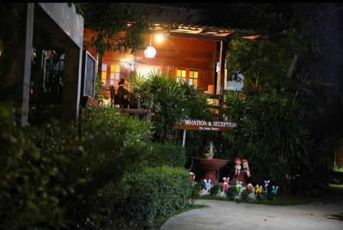 a group of people sitting on a bench in front of a building at Pai Loess Resort in Pai