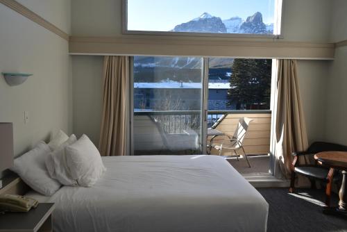 a hotel room with a bed and a large window at The Drake Inn in Canmore