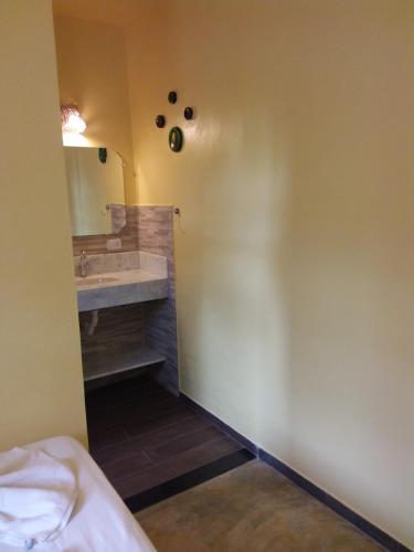 a bathroom with a sink and a mirror at Pousada Das Cores in Cumuruxatiba