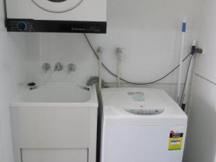 a kitchen with a sink and a washing machine at Costa D'Ora Holiday Apartments in Gold Coast