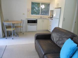 a living room with a couch and a kitchen with a table at Costa D'Ora Holiday Apartments in Gold Coast