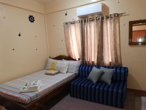 AN Velayo Homestay (ANVEL) في باسكو: غرفة نوم صغيرة مع سرير وأريكة