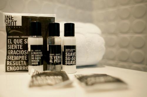 three bottles of hair products sitting on a bathroom counter at One Shot Prado in Madrid