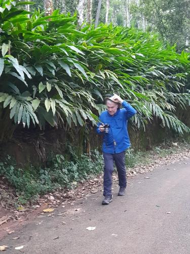 a man walking down a road with his hand on his head at Spice Villa Thekkady in Thekkady