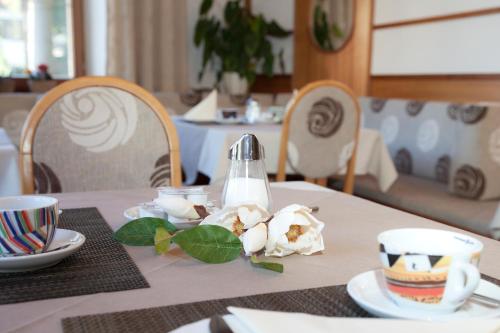 Hotel Garni Gletschertor في أوتزال باهنهوف: طاولة عليها مفرش وطاولة بيضاء وأكواب