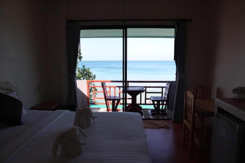 a bedroom with a bed and a view of the ocean at Bamboo @ Koh Chang in Ko Chang