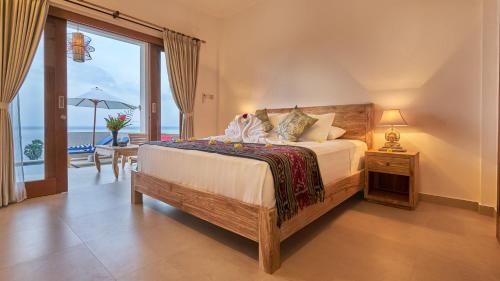 a bedroom with a bed with a view of the ocean at Villa Aska in Amed