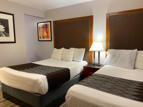 a hotel room with two beds and a lamp at Colonial Motel in Santa Maria