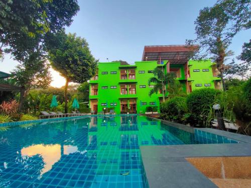 a hotel with a swimming pool in front of a building at Morakot Lanta Resort in Ko Lanta