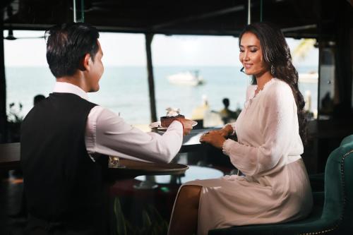 a man handing a woman a piece of cake at Queenco Hotel & Casino in Sihanoukville