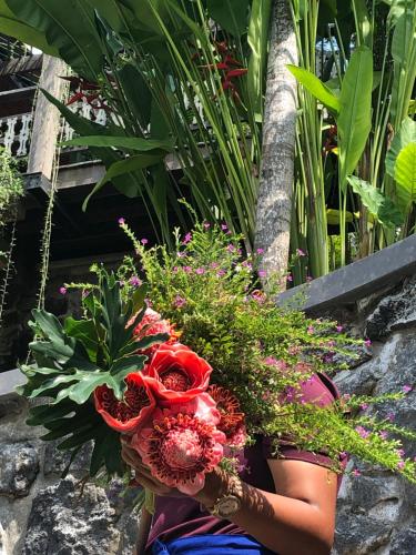 a woman is holding a bouquet of flowers at Puri Kasih Gottlieb in Ubud