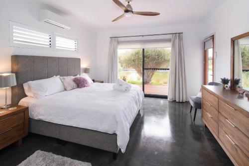 a bedroom with a large bed and a large window at Wharfedale in Wilyabrup