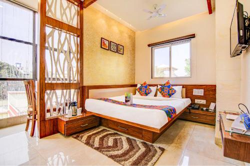 a bedroom with a bed and a window at FabHotel The Khushi Regent in Bhopal