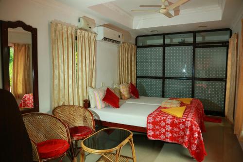 1 dormitorio con 1 cama con mesa y sillas en Marari Nest Beach Homestay, en Mararikulam
