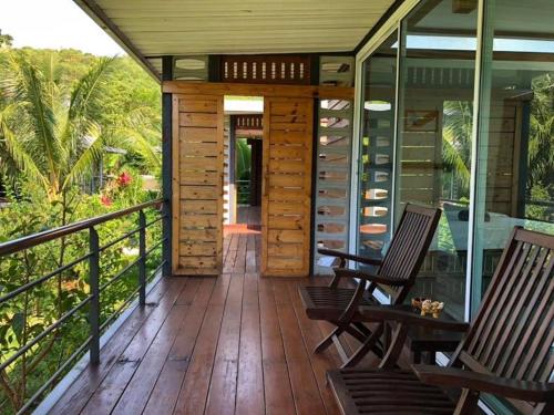 a screened in porch with two chairs and a table at Baan Boom Boxes Eco Friendly Resort in Mae Nam
