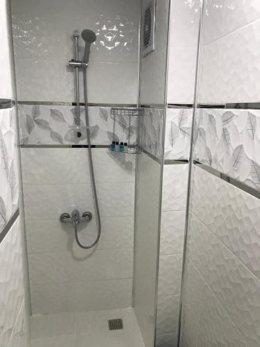 a shower stall in a bathroom with white tiles at Beyhan Hotel in Istanbul
