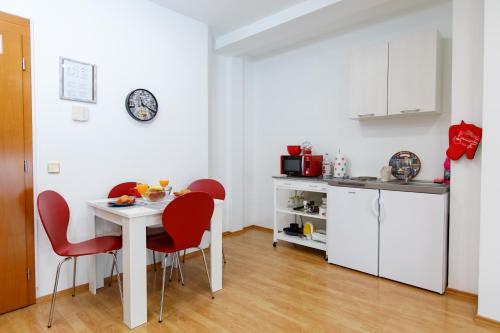 eine Küche mit einem Tisch und roten Stühlen in einem Zimmer in der Unterkunft Apartments Midnight City in Dubrovnik