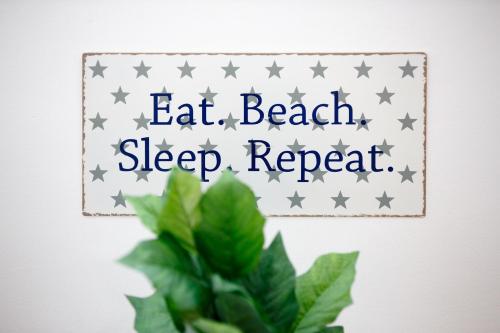 une pancarte avec les mots « mangez à la plage, dormez à nouveau et une plante » dans l'établissement Apartments Midnight City, à Dubrovnik