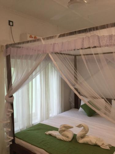 two swans laying on a bed in a bedroom at Sea Close Inn in Ahangama