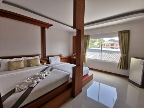 a bedroom with two beds and a large window at The Peace Tara House in Ko Lanta