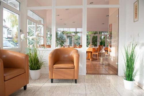 a lobby with two chairs and a table at Hotel Angermeier GARNI in Eching