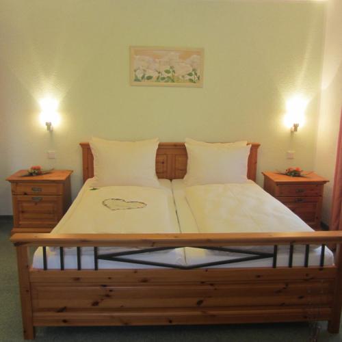 a bedroom with a wooden bed with two night stands at Hotel Angermeier GARNI in Eching