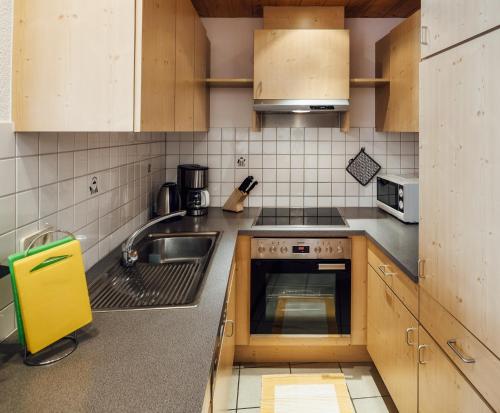 a small kitchen with a sink and a stove at Apart Ideal Serfaus in Serfaus