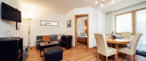 a living room with a table and a dining room at Apart Ideal Serfaus in Serfaus