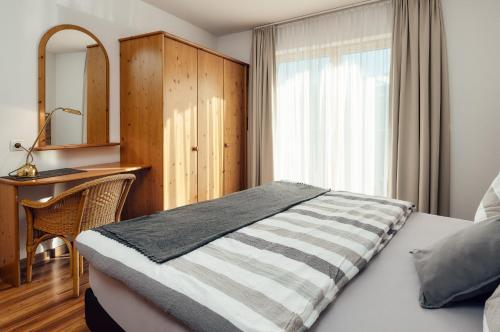 a bedroom with a bed and a desk and a window at Apart Ideal Serfaus in Serfaus