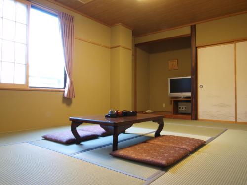 a living room with a coffee table and a window at Hakuba Hotel Hana-no-Sato in Hakuba