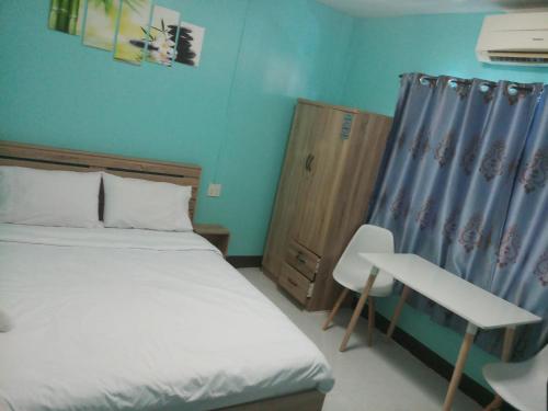 a bedroom with a bed and a desk and a chair at Kata S. T. House in Kata Beach