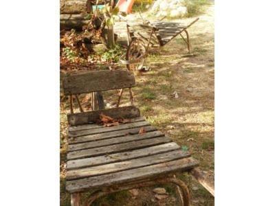 an old wooden bench sitting in the grass at B&B Monferrato La Casa Sui Tetti in Murisengo
