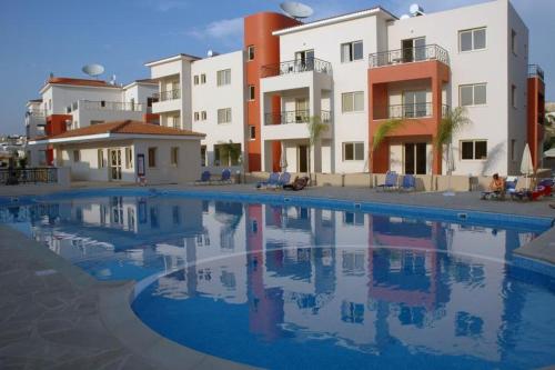 une grande piscine en face de certains bâtiments dans l'établissement Ifestos Kings Resort Appartment, à Paphos