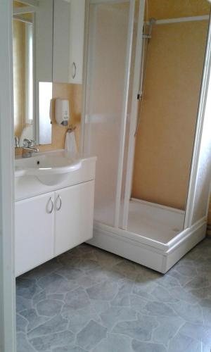 a white bathroom with a shower and a sink at Furoy Fishingcamp and Hotel Apartments in Sorreisa