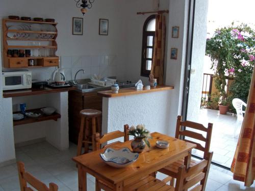 a kitchen with a wooden table with chairs and a counter at Dolphins in Elounda