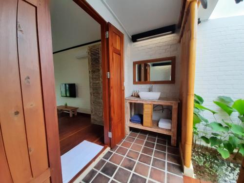 a bathroom with a sink and a mirror at The Kelong Trikora Resort in Kangkakawal