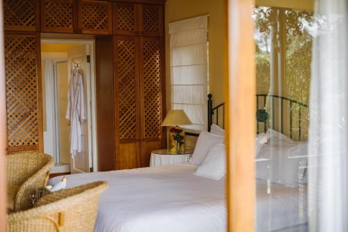 um quarto com uma cama grande e uma cadeira em High Timbers Lodge em Tokai