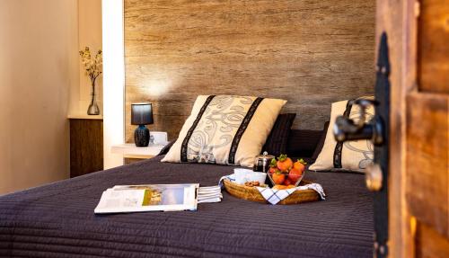a bed with a basket of fruit and a book on it at Es Fasser in Alcudia