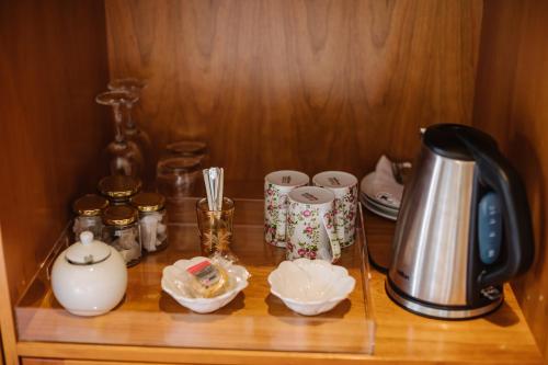 a shelf with a tea kettle and cups on it at High Timbers Lodge in Tokai