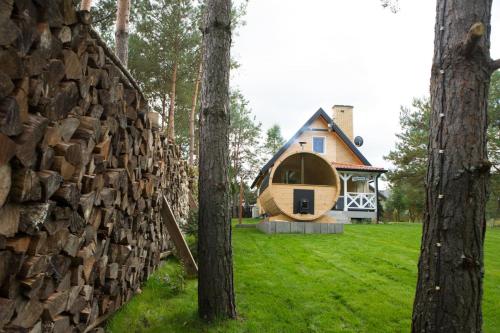 a house in the woods with a stack of logs at Relax House Narty in Narty